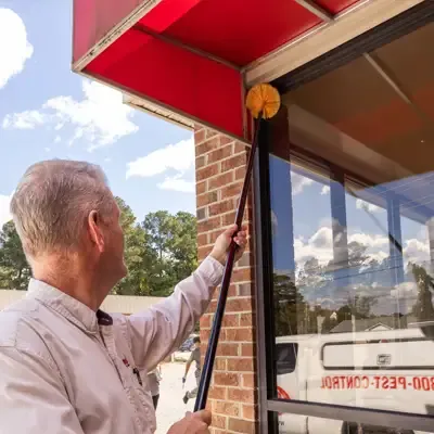 pest technician sweeping building